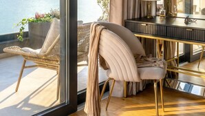 Una habitación moderna con un ventanal grande, una silla, una mesa y un espejo.
