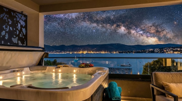 Uma banheira de hidromassagem com vista para a cidade e um céu estrelado.