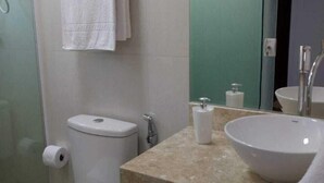 Un baño con inodoro, lavabo y espejo.