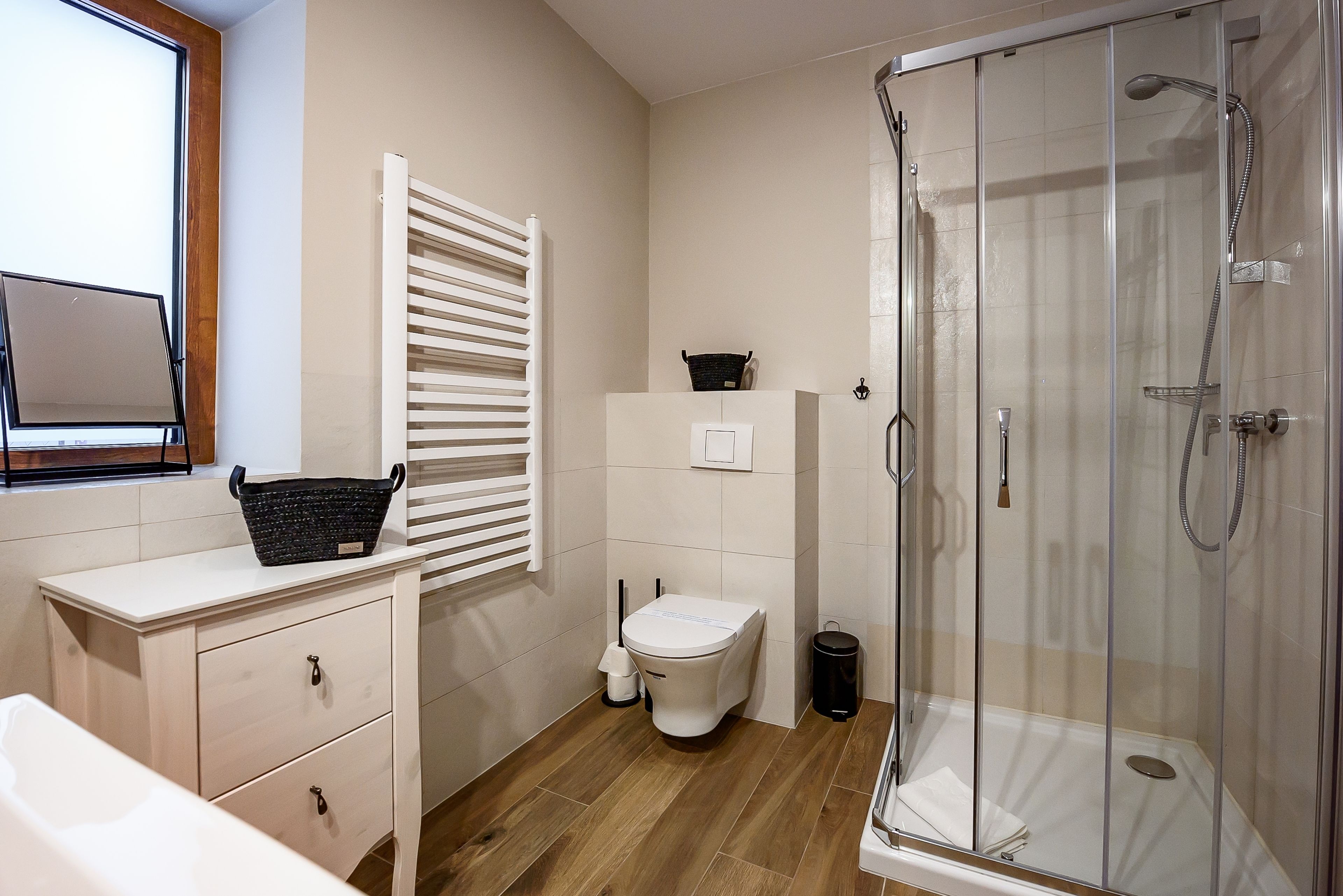 Un baño moderno con inodoro, bidé y ducha con mampara de vidrio.