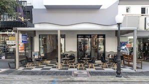 A hotel with outdoor seating and a checkered floor pattern. - N E P center Hotel Rodos (Rhodes)