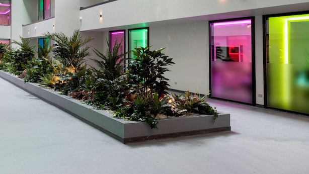 Een meerlaags interieur met balkons, een dakraam en kamerplanten.