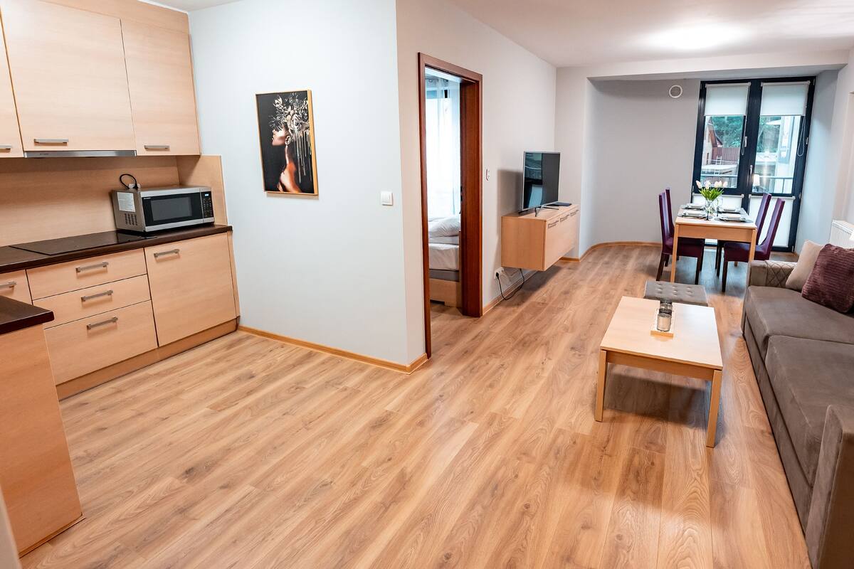 A modern apartment with a kitchen, dining area, and living room.