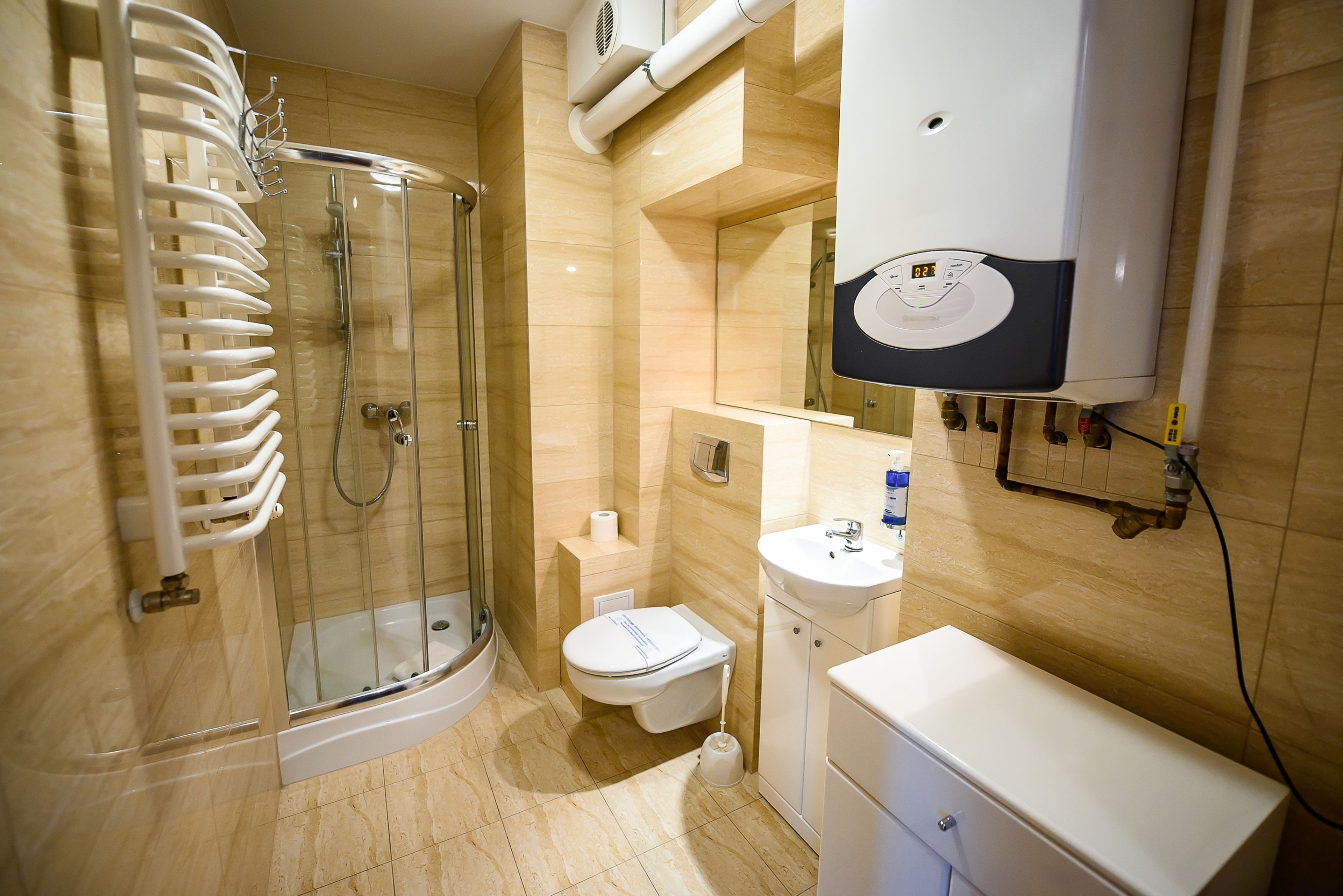 A modern bathroom with a glass-enclosed shower, a toilet, a sink, and a cabinet.