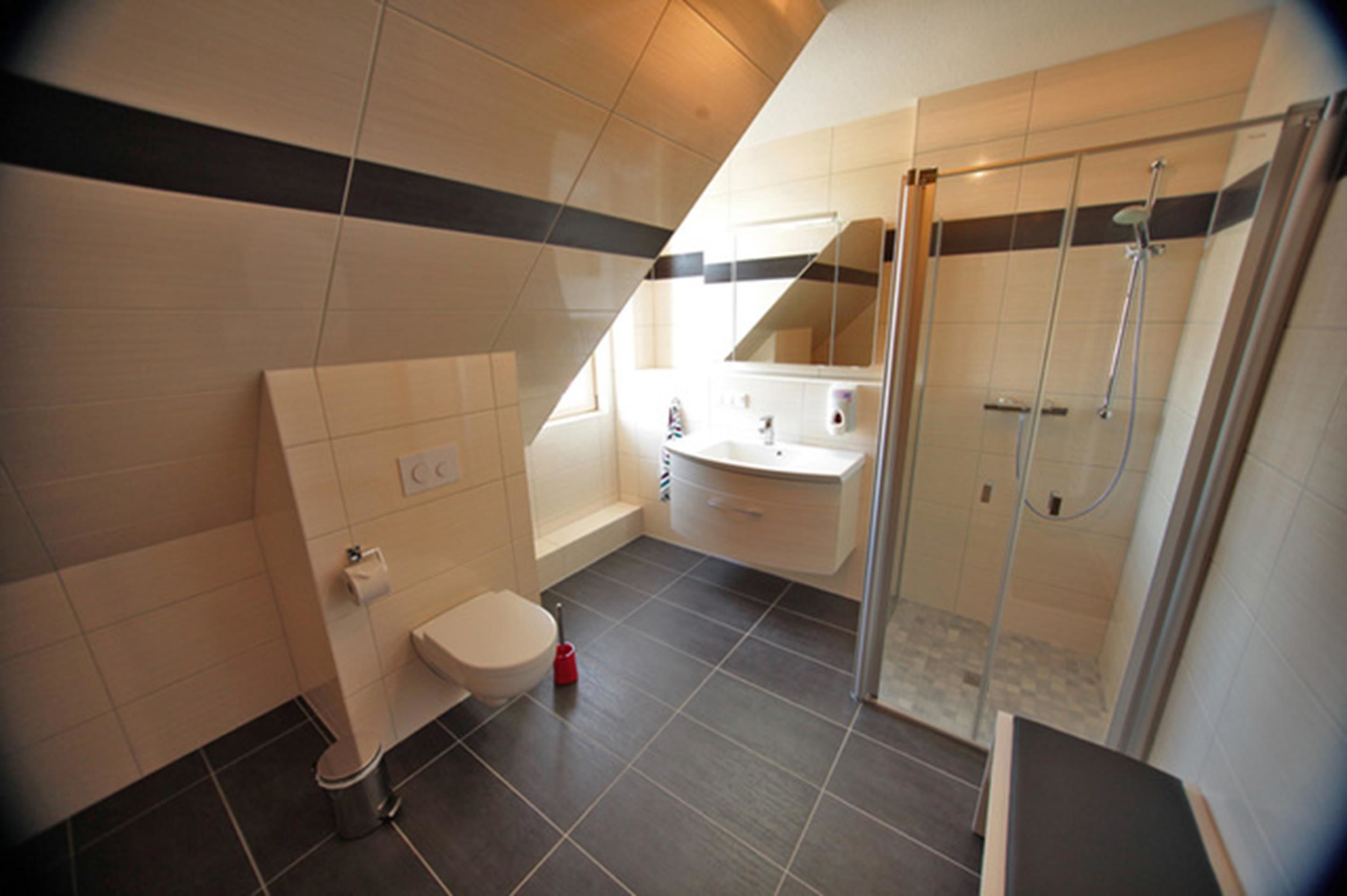 Un baño moderno con ducha, inodoro y lavamanos.