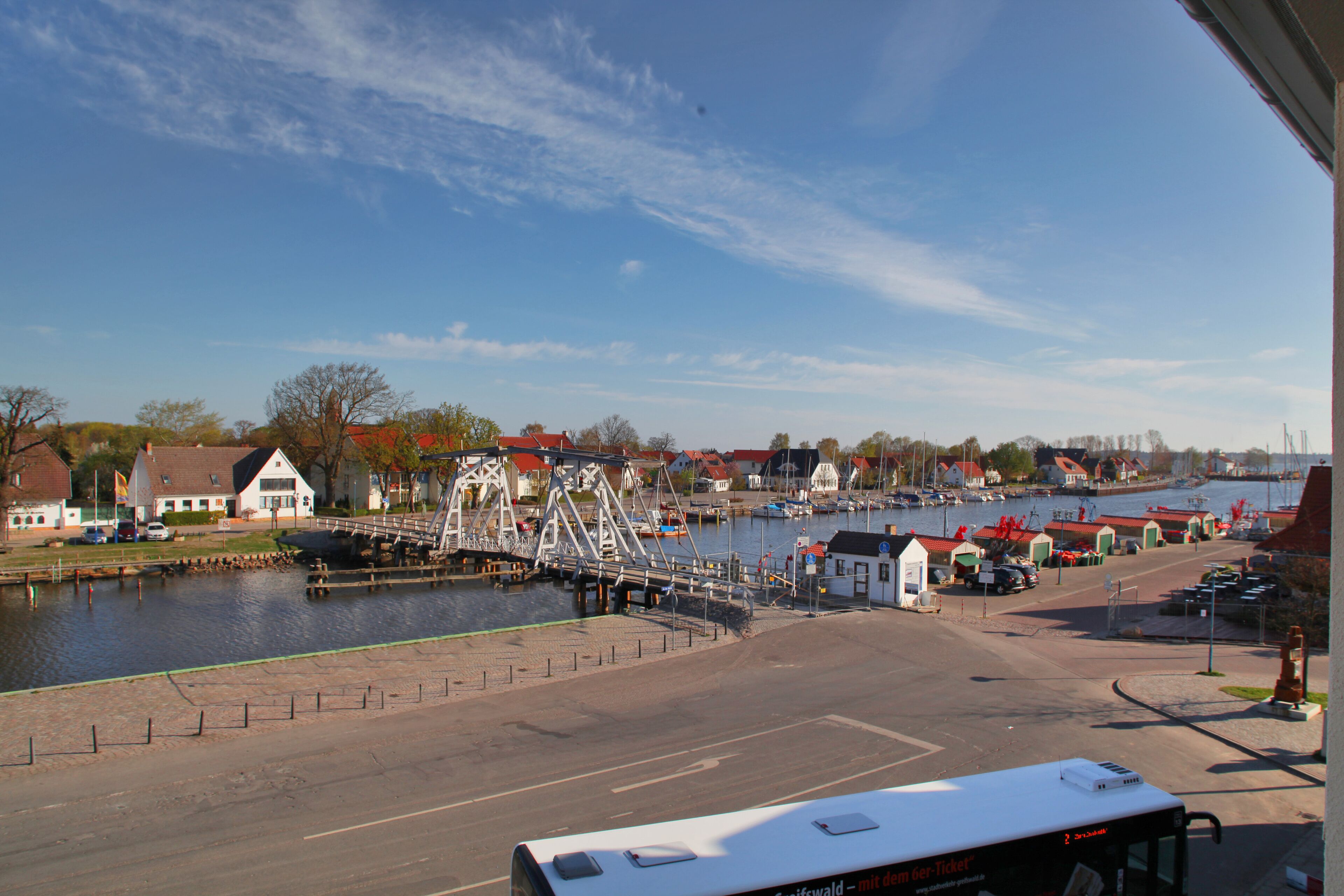 A riverside view with a bridge, boats, and buildings along the water.