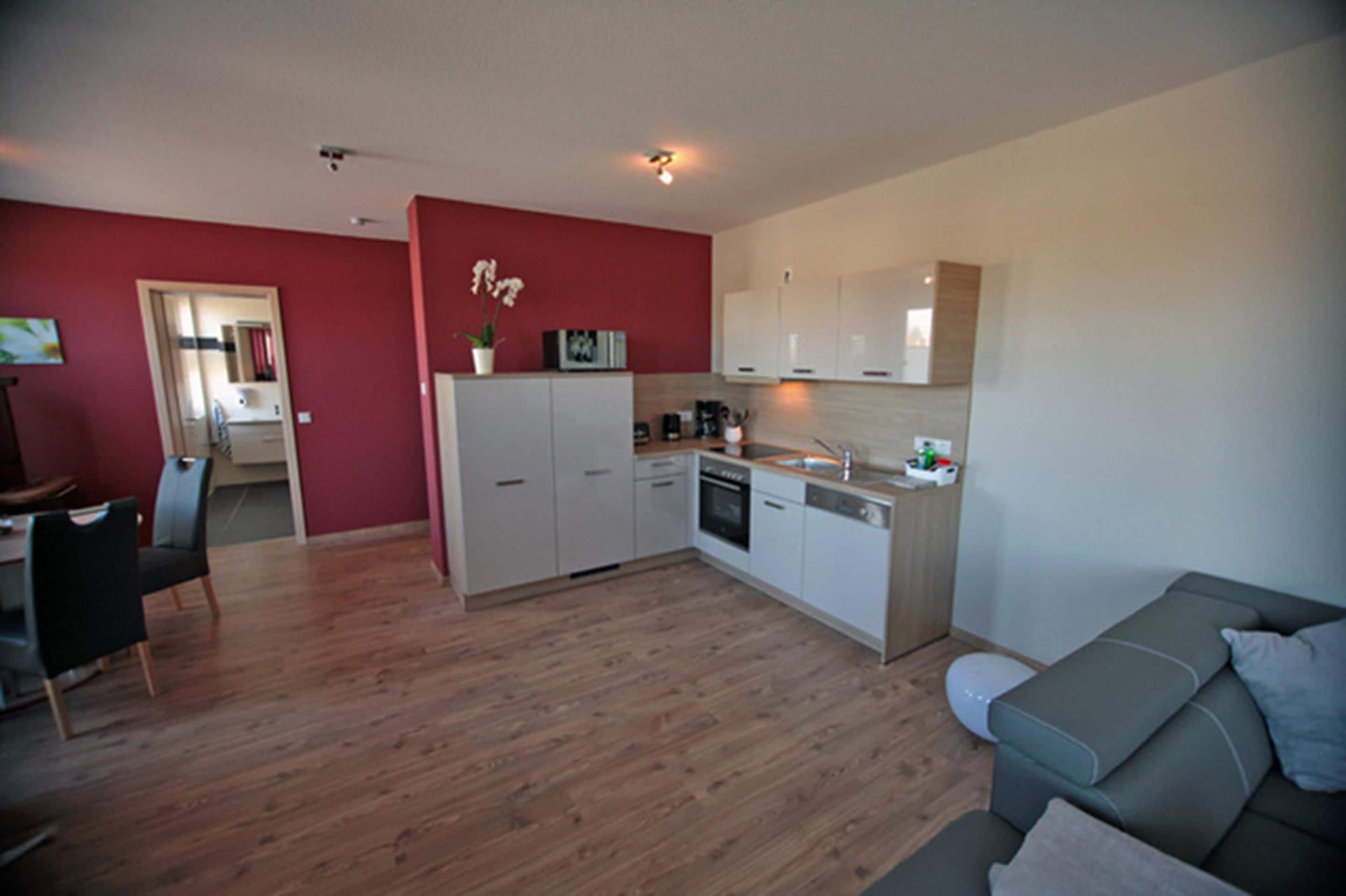 A compact living space with a kitchenette, dining area, and a sofa.
