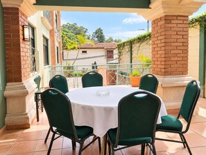 A round table with six chairs, a white tablecloth, and a glass on the table. - Hotel El Picacho (Tegucigalpa)