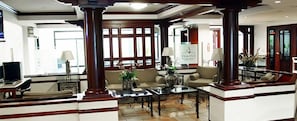 A spacious lobby with high ceilings, large windows, and a central seating area with sofas and a coffee table. - Hotel El Picacho (Tegucigalpa)