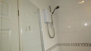 A bathroom with white tiled walls, a glass shower enclosure, and a showerhead mounted on the wall. - Dryden House (Chesterfield)