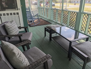 Relax on the covered porch with two comfortable chairs and a small table.