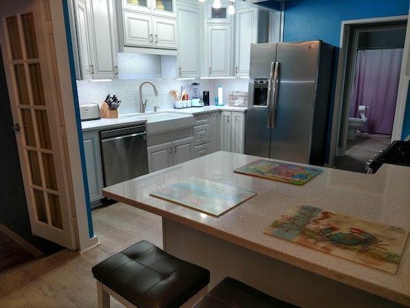 Enjoy cooking in this well-equipped kitchen with a refrigerator, dishwasher, and island.