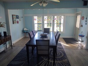 Enjoy meals in this cozy dining area with a long table and comfortable chairs.