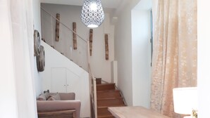 A staircase with wooden steps and a handrail, leading to a landing with a bench and a table. - Lefkada Princess (Lefkada)