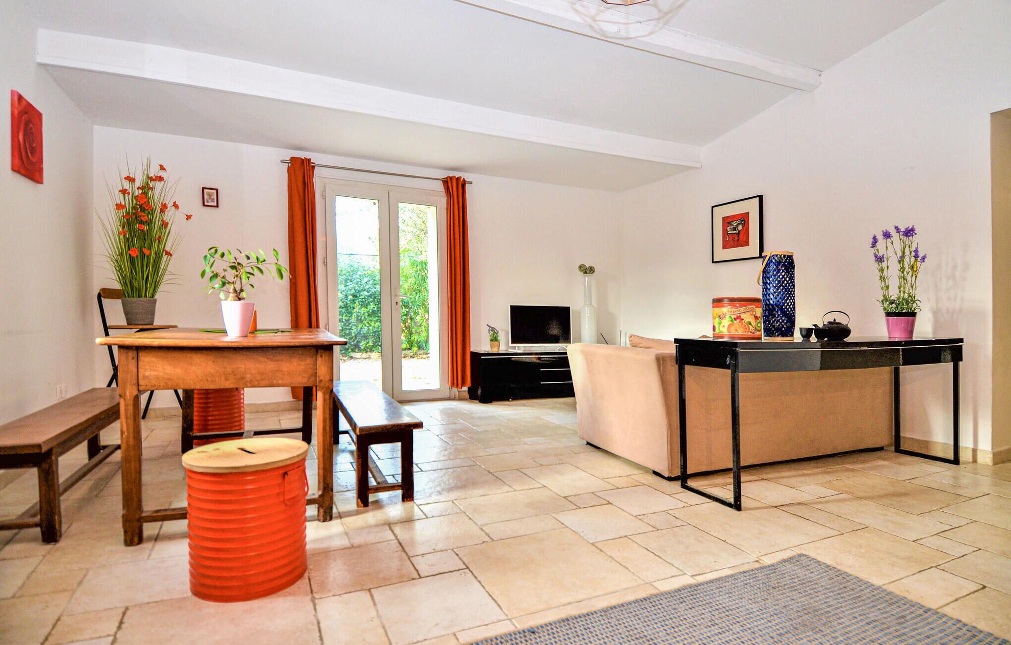 Un salon comprenant un canapé, une table basse, un téléviseur et un coin repas avec une table et des chaises.