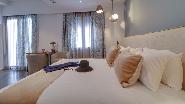 A hotel room with a large bed, a desk, and curtains. - AthiNN Residence (Athens)