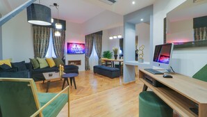 A modern living room with a sofa, coffee table, and a desk with a computer. - AthiNN Residence (Athens)