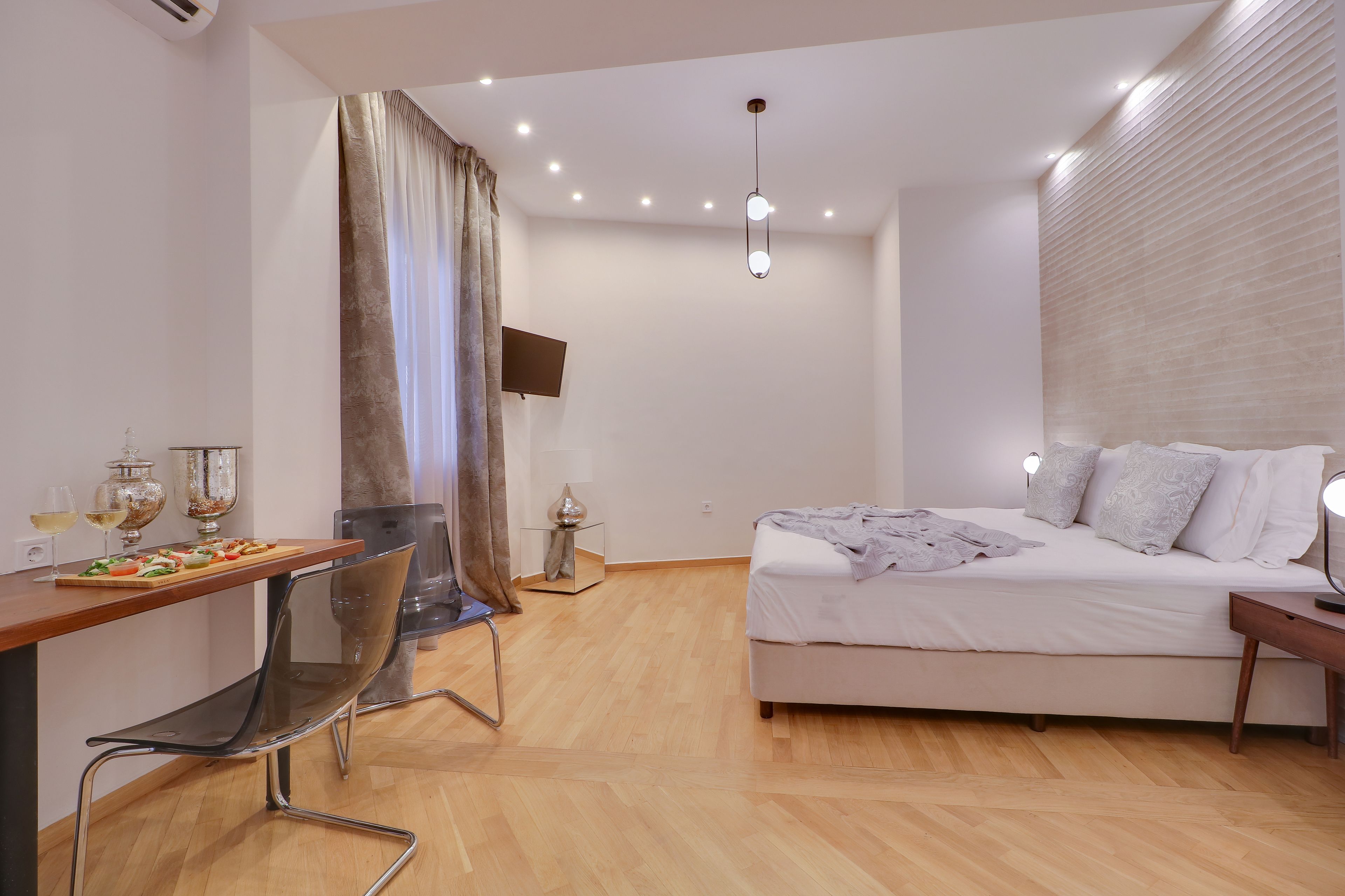 A modern bedroom with a bed, bedside table, and a desk with a chair.