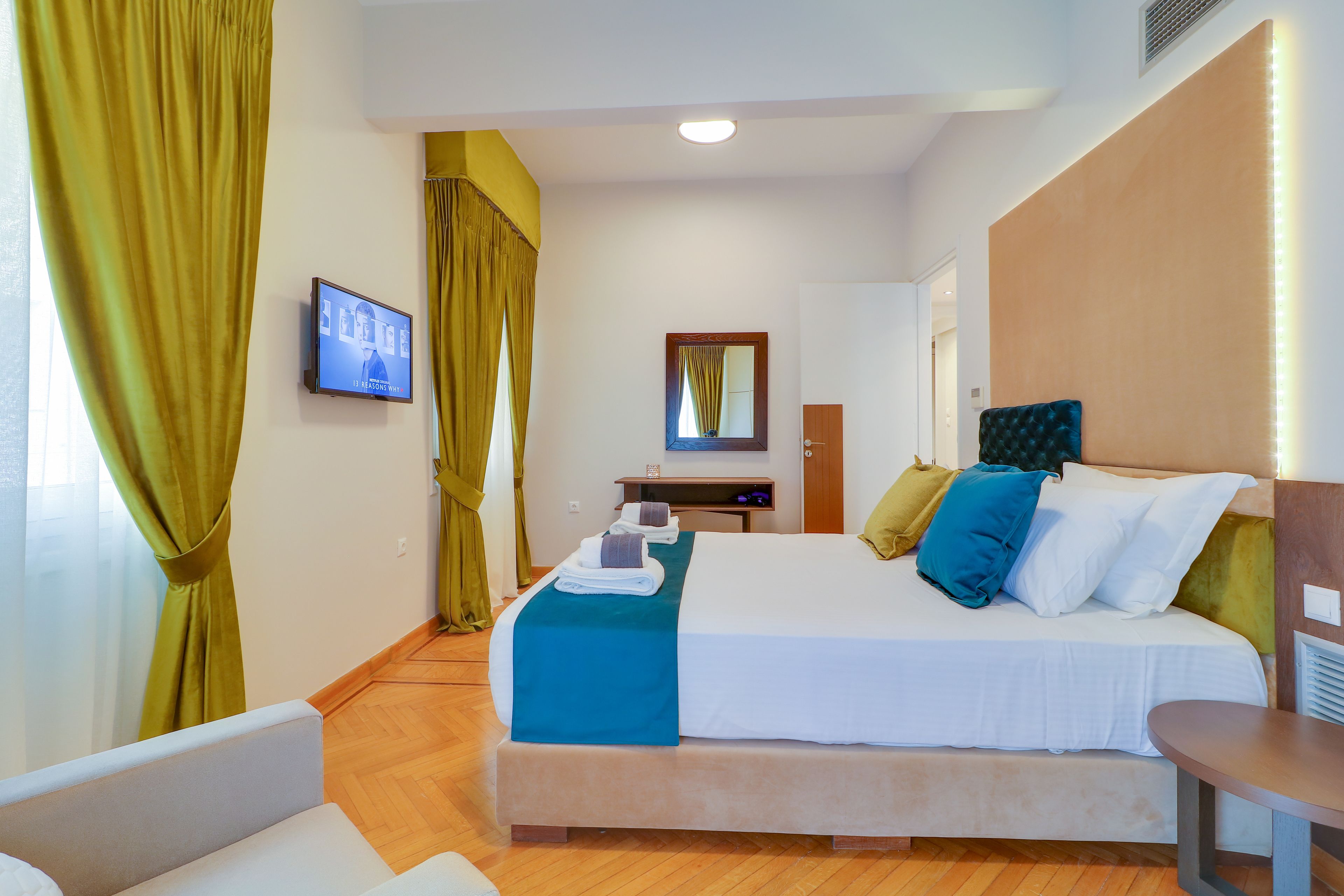 Ein Hotelzimmer mit Bett, Schreibtisch, Stuhl und Fernseher.