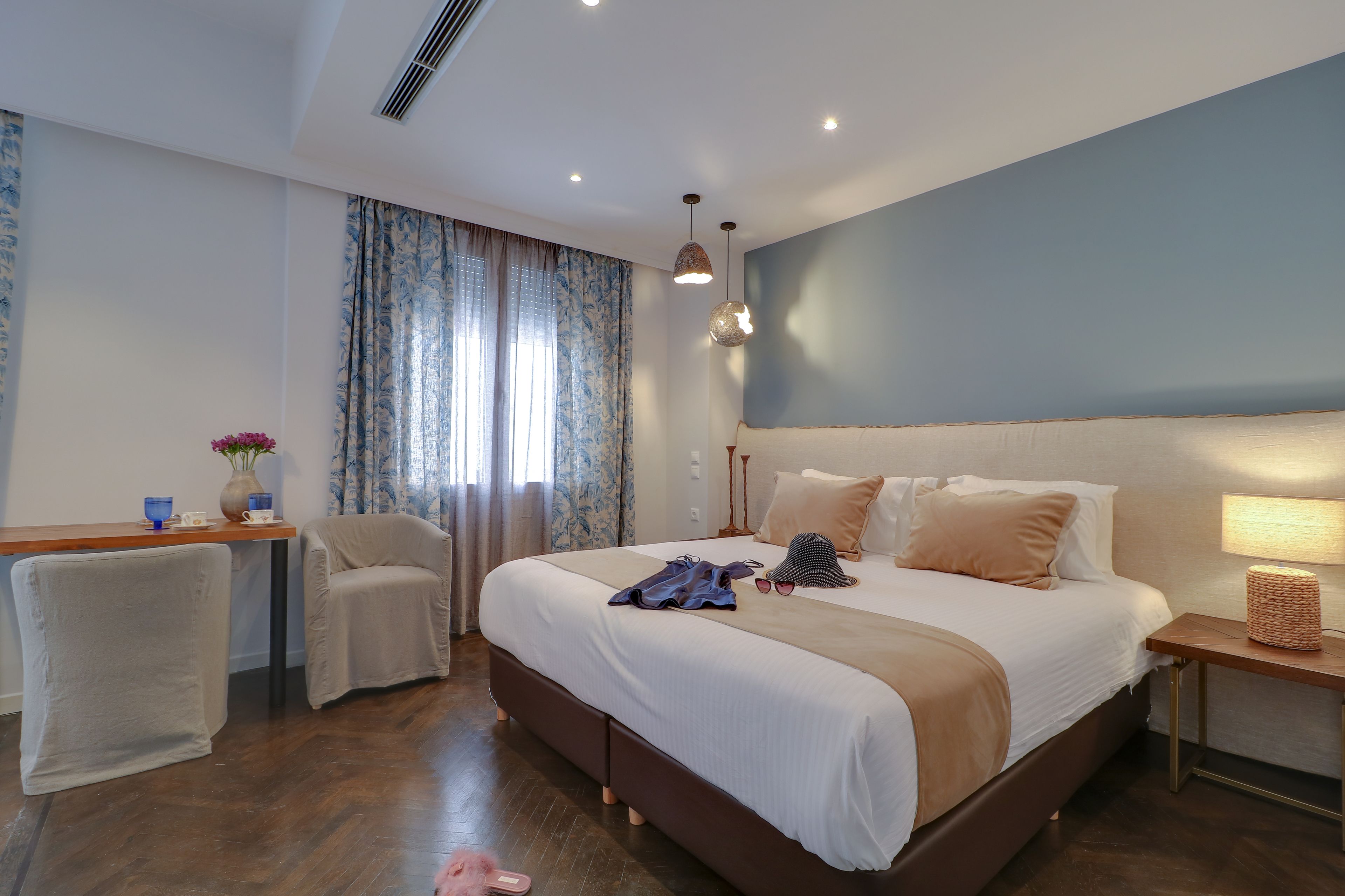 Une chambre d’hôtel moderne avec un grand lit, un bureau, une chaise et une lampe.