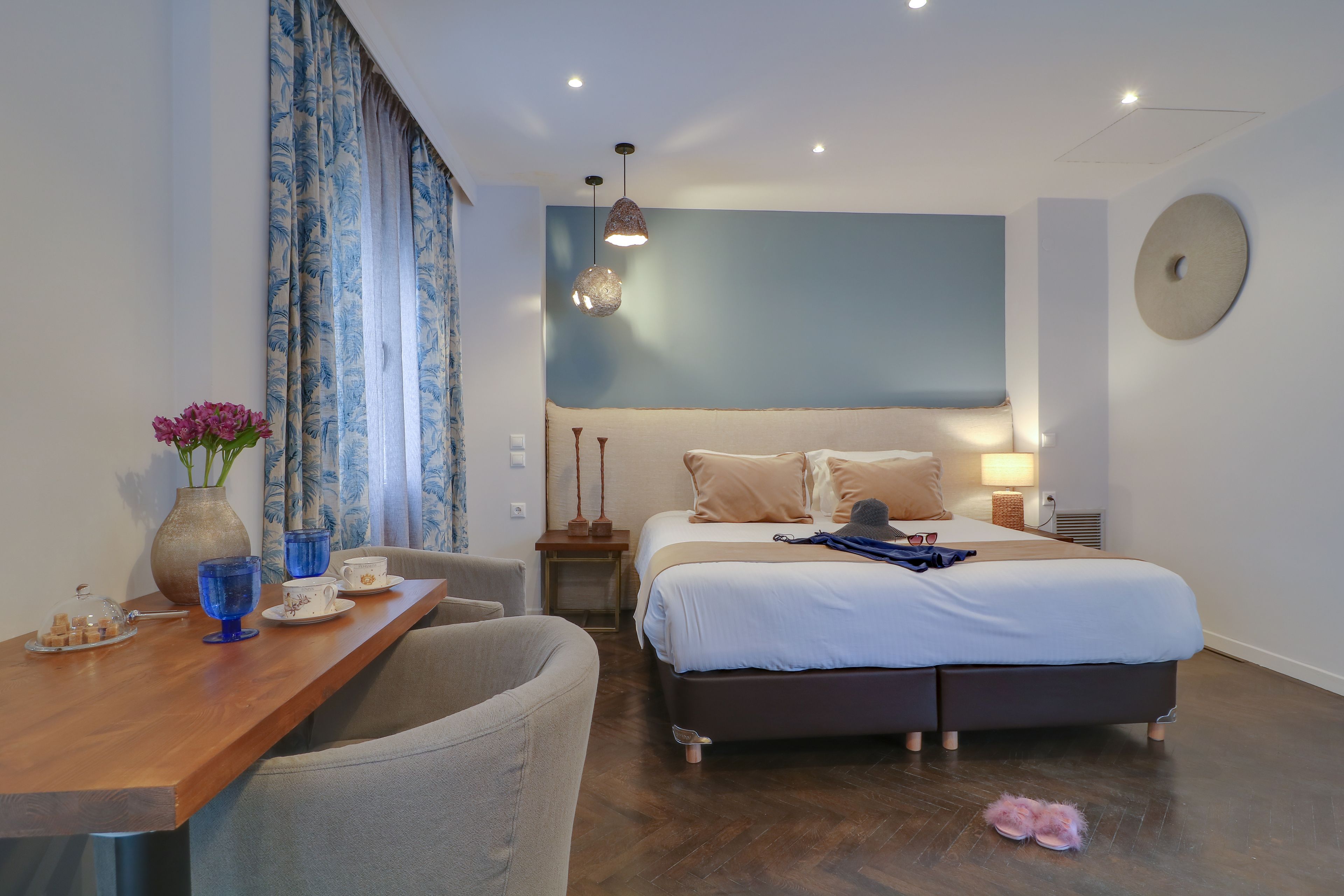 A bedroom with a bed, bedside tables, a desk with a chair, and a window with curtains.