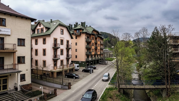 Un hôtel à plusieurs étages doté de balcons, d’un parking et offrant une vue sur la rivière.
