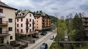 A multi-story hotel with balconies, a parking area, and a river view.