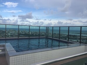 Une piscine à débordement située sur le toit, offrant une vue panoramique sur la ville.