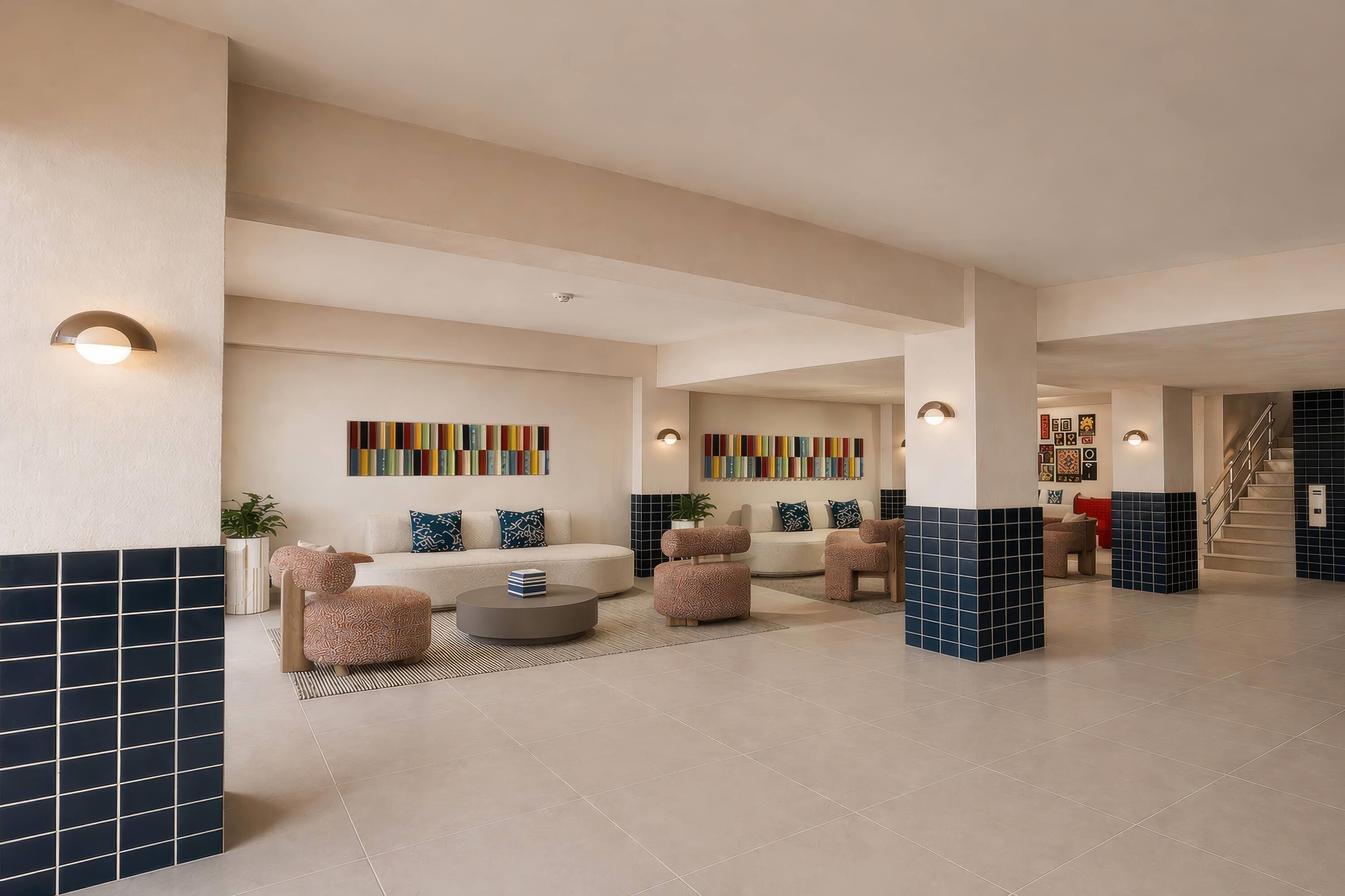 A modern interior with a central seating area, a staircase, and a hallway leading to another room.