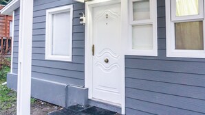 A house with a white front door, a small porch, and a window with a curtain. - Gente del Sur - Gobernador Paz (Ushuaia)