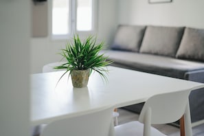 A modern living room with a white sofa, a white table, and a potted plant. - Gente del Sur - Gobernador Paz (Ushuaia)
