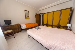 A bedroom with a bed, a dresser, a chair, a desk with a computer, and a wardrobe. - B&B 32 (Ciampino)