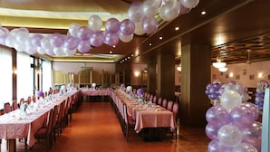 A banquet hall with long tables set for a formal event, decorated with purple and white balloons. - Hotel Dolomiti Levico (Levico Terme)