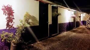 A row of hotel rooms with individual doors, some with plants hanging outside. - Cabaña Miroji (Zacatlán)