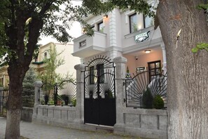 A building with a black iron gate, stone pillars, and a sign above the entrance. - Eagles Philadelphia Hotel (Korçë)