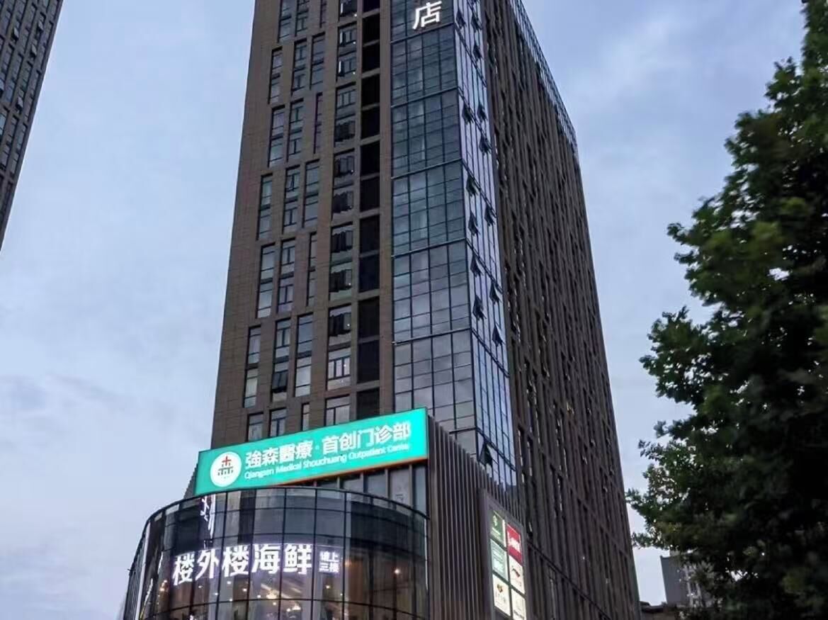 A tall building with a sign indicating a medical facility on the lower level.
