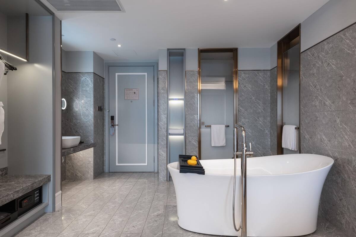 A modern bathroom with a freestanding bathtub, a vanity with a sink, and a shower area.
