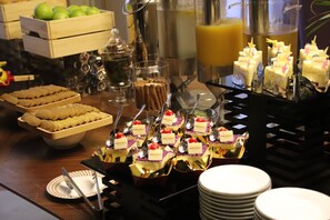 A buffet with various food items, including cakes and pastries, arranged on a table. - Mercure Xian North (Xi'an)