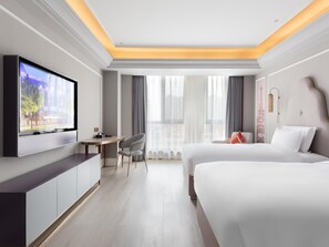 A hotel room with a bed, a desk, a TV, and a view of the city. - Mercure Xian North (Xi'an)