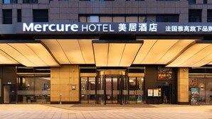 A hotel entrance with a sign reading 'Mercure HOTEL' and a revolving door. - Mercure Xian North (Xi'an)