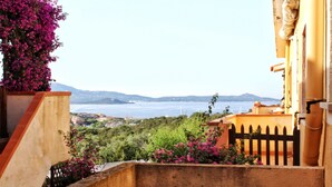 A balcony with a view of the sea and distant hills. - Porto Rotondo Garden Flats (Olbia)