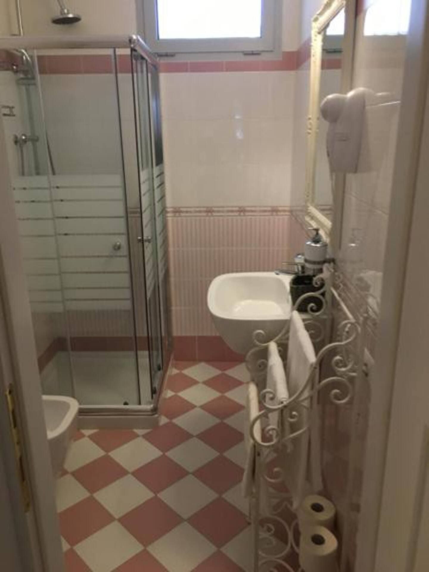 A bathroom with a glass shower enclosure, a sink, and a toilet.