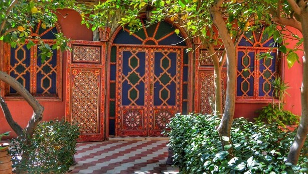 Un edificio tradicional con puertas ornamentales y un suelo a cuadros.