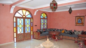 Una habitación con un amplio arco de entrada, una mesa redonda y un conjunto de sofás.