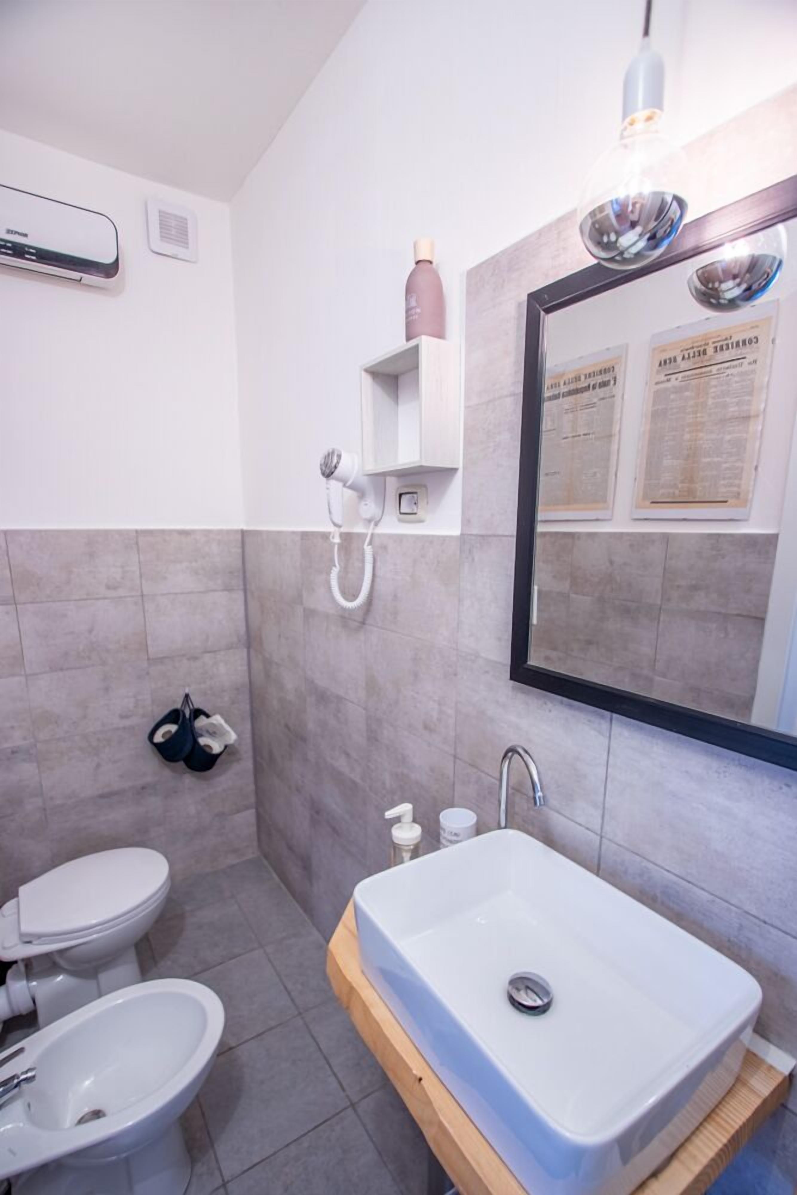 Une salle de bain moderne avec un lavabo blanc, un miroir et un porte-serviettes.