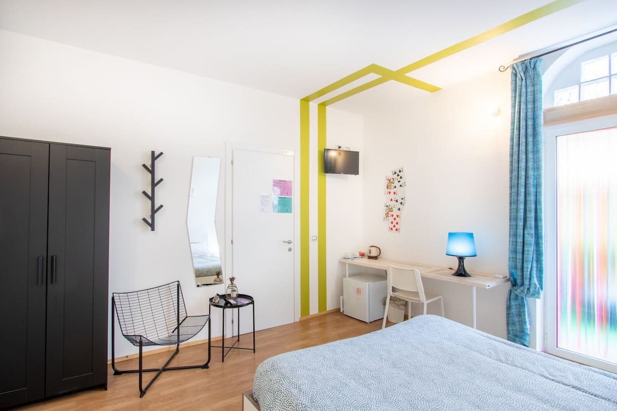 Un dormitorio moderno con cama, escritorio, silla y armario.