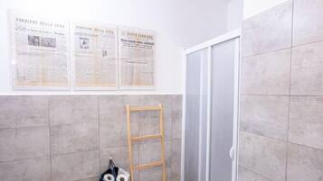 Un baño con inodoro, una escalera de madera, un perchero para toallas y zona de ducha.