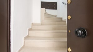 A staircase leading to a landing with a door featuring a brass handle and a keyhole.