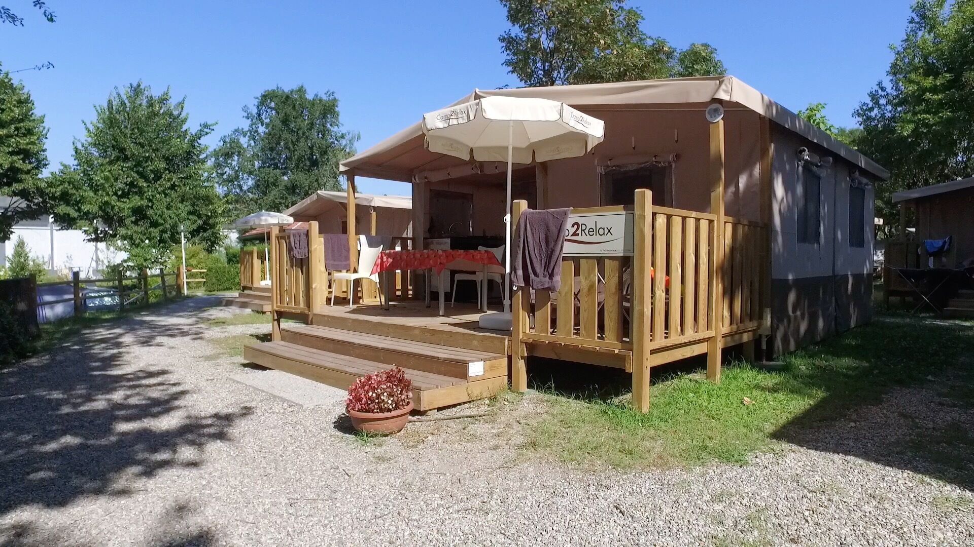 Ein Holz-Mobilheim mit Veranda, Tisch und Stuhl.