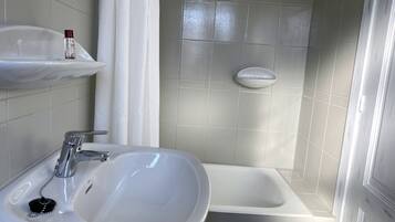 Une salle de bain avec un lavabo, un miroir et un espace douche.